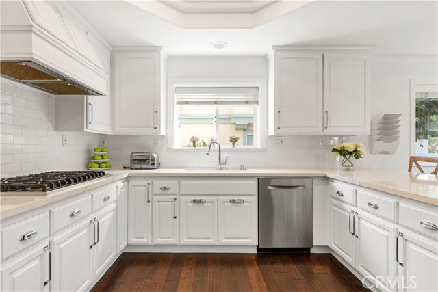 Kitchen is equipped with Viking cooktop, custom vent hood, Bosch dishwasher.