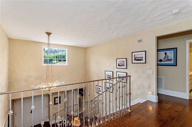 View of the front door, entryway and staircase from the second floor landing.