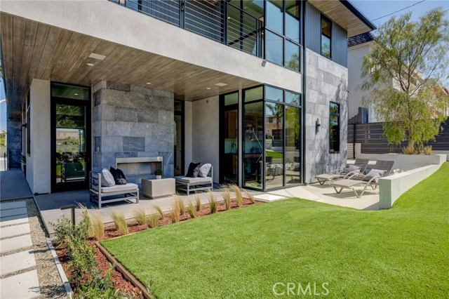 West side yard with outdoor fireplace and lounge area.