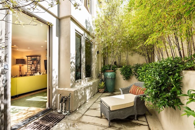 The family room leads to a private patio with lush foliage.