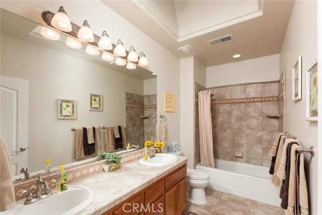 Main bathroom with double sinks, tub and shower, tile floors.