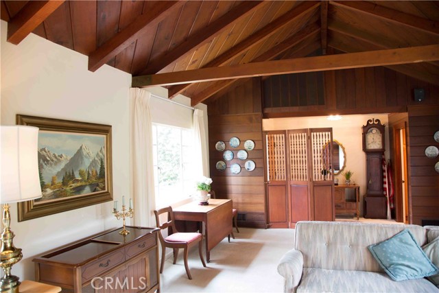 Large living/dining room with pitched beam ceilings.