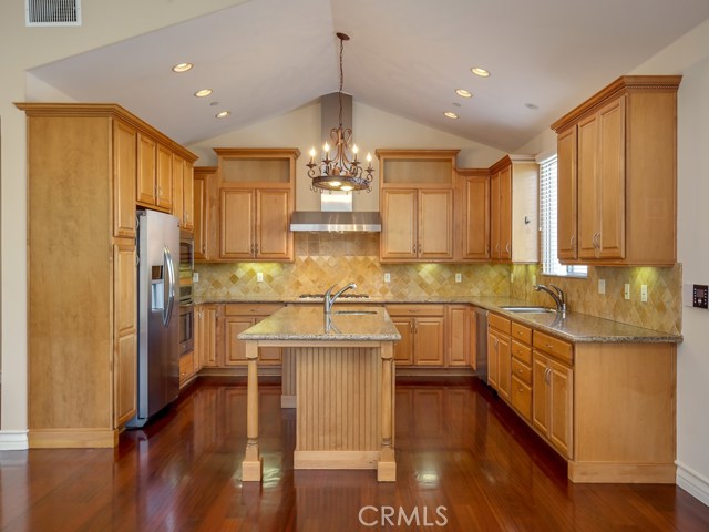 Kitchen has maple cabinets, granite counters, and stone backsplash.