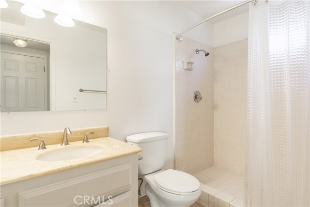 main level bathroom with newly updated fixtures, lighting, and mirrors