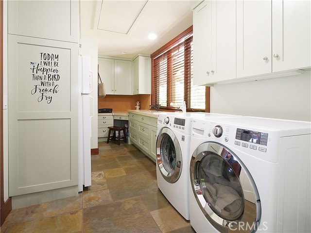 Laundry room includes a home office area plus an extra refrigerator.