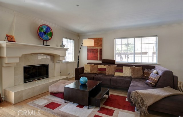 Great room includes hardwood floor, stone faced fireplace hearth and large windows