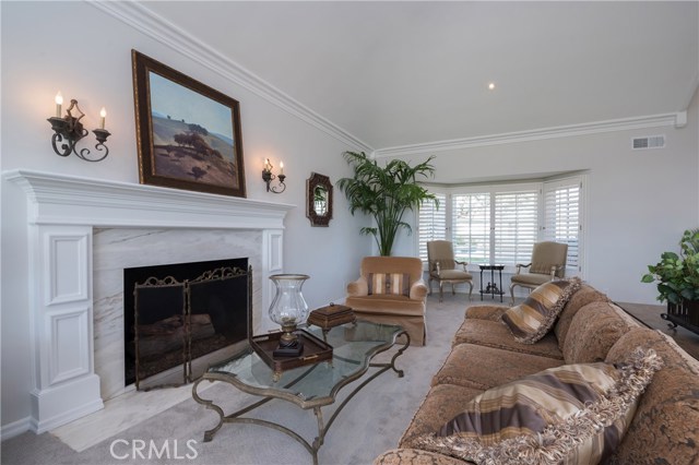 Close up photo of the fireplace in the living room.  The window looks out to the front of the house.