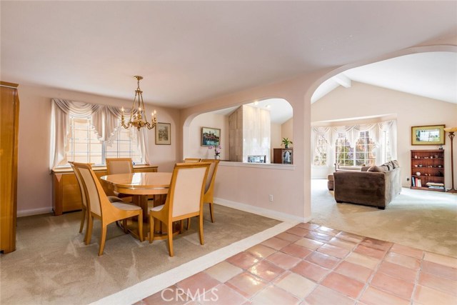 Dining room looking to living room with lots of natural light and a fireplace.