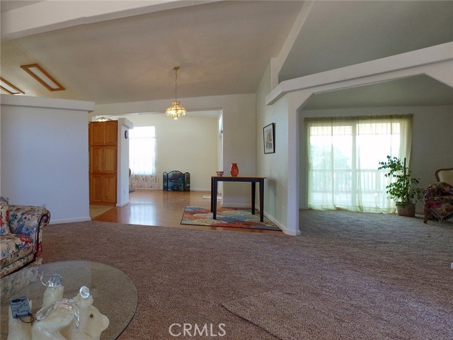 At the front entrance, you'll see the bonus room with its sliding glass door to the large covered back deck, the front sitting room, and the beginning of the large open kitchen.