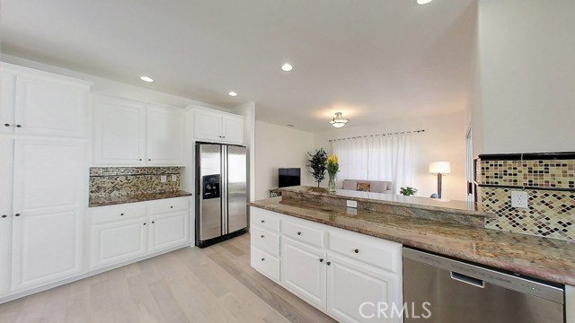 Lots of storage, plenty of floor space, beautiful and functional natural stone counters, light and bright, it's everything you'd want in a kitchen. It also opens up to the family room and bar stool area for those that want to hang out and socialize as your working your magic in the kitchen. The family room also flows to the other outdoor patio area through another sliding glass door. The bathroom and direct garage access is adjacent to family room and makes it easy and convenient to carry in groceries. The