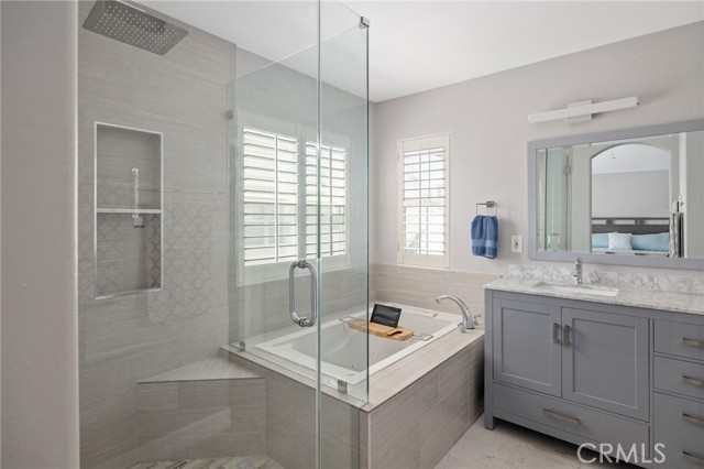 primary bathroom featuring shower, soaker tub, and double sink vanity primary bathroom featuring shower, soaker tub, and double sink vanity