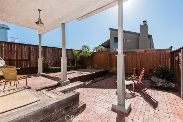 Backyard with brick surface and newer wood fencing.  Lot is a bit wider than standard.