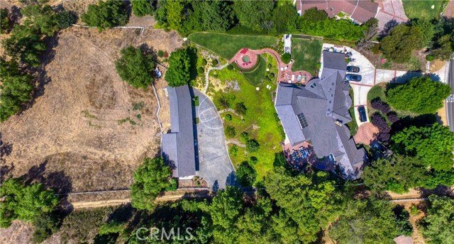 Situated on over 2.5 acres, this property offers a 5 bed/4.5 bath home with an additional 1 bed/1 bath guesthouse. There's also a barn, in ground spa, multiple patios, sports court and huge corral which may accommodate a tennis court.