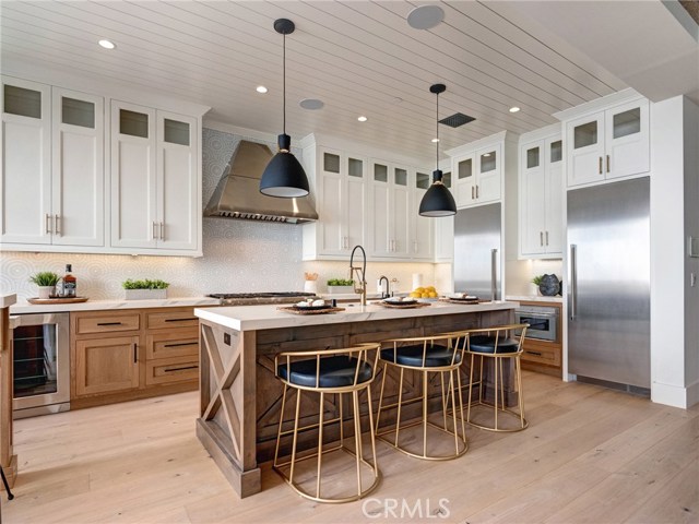 Neolith stone counters, Thermador professional series appliances, dual sinks, additional beverage fridge, Brizo faucets, breakfast counter, indoor/outdoor bar & entertainment area.