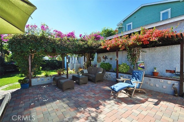 Another view of the backyard patio lined with pavers  and plenty of shade