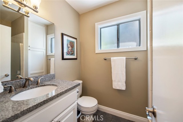 Downstairs bathroom with granite counters, tile flooring, new fixtures and a shower