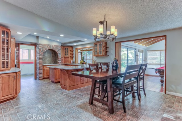 Dramatic view of spacious remodeled kitchen and den/recreation room from dining room