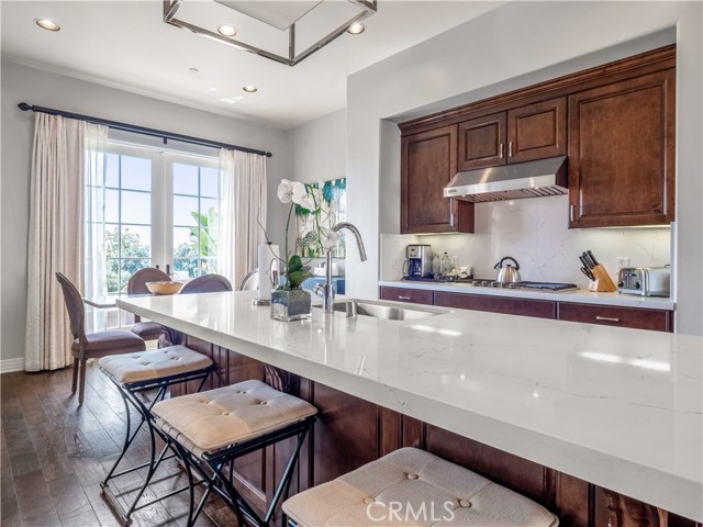 Fully appointed gourmet, dine-in kitchen with French doors leading to a sweeping outdoor patio.