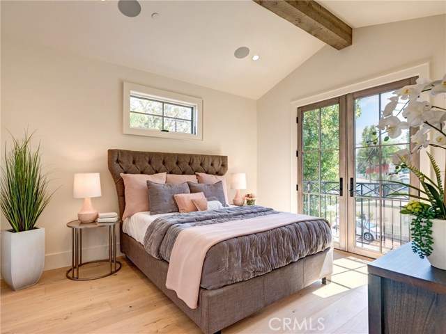 Upstairs bedroom suite #2 with Juliet balcony, Trestlewood accent wood beam, whole home surround sound.
