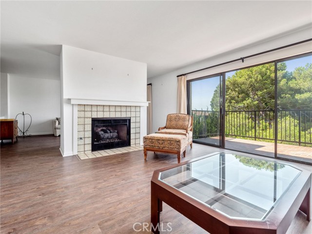 Living room with new flooring opens to den, deck, (windows with newer window coverings)