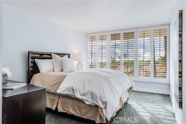 Guest bedroom with plantation shutters and a view to the ocean.