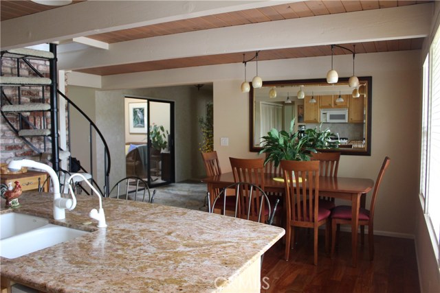 view from stove and behind eating bar of kitchen and study area