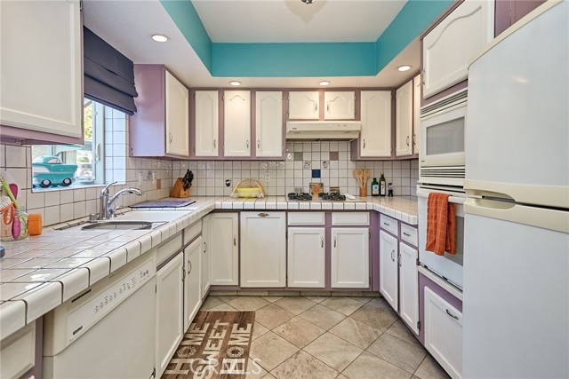 The kitchen with quartz tile flooring is done to the owners taste and style.