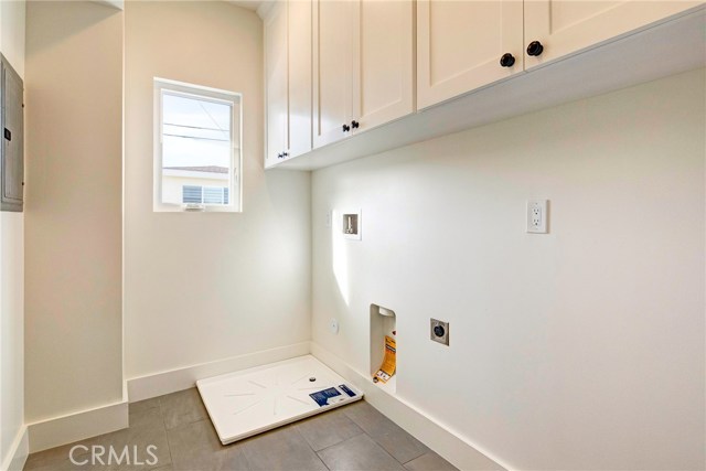 Upstairs separate laundry room with storage cabinets.