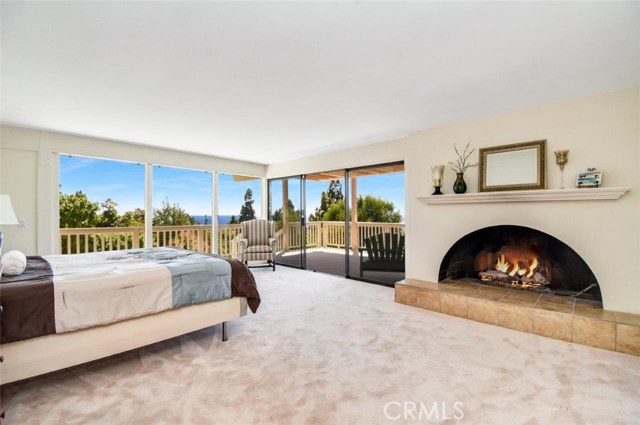 Master bedroom with ocean view and cozy fireplace