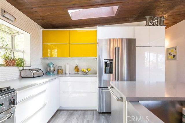 Super Chic open kitchen with two skylights and island with quartz countertops and stainless appliances