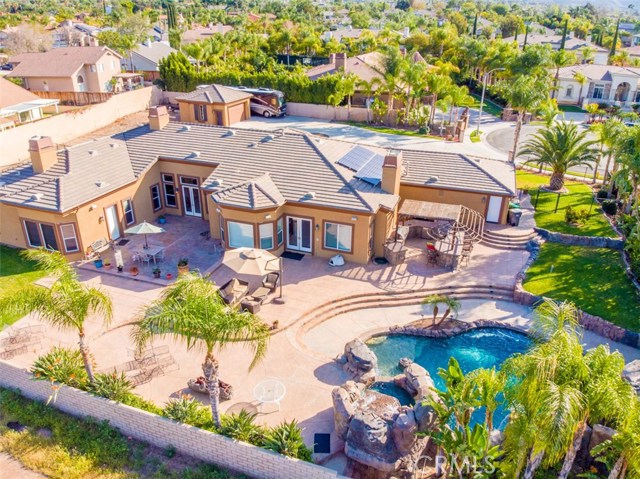 Overlooking the Backyard Space with Pool, Spa, Waterfalls and Built-in Covered Entertainment area, with BBQ, refrigerator, and Palapa.