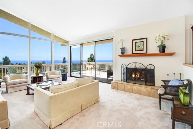 Living room with vaulted high ceiling and floor to ceiling picture windows and over-sized sliding doors to capture the panoramic ocean views