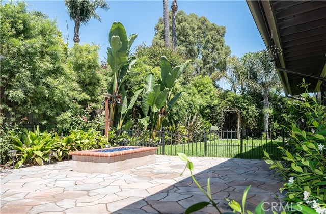 Firepit is on patio adjacent to outdoor kitchen. Next to the firepit, a grassy area perfect for pets, kids or a game of croquet!