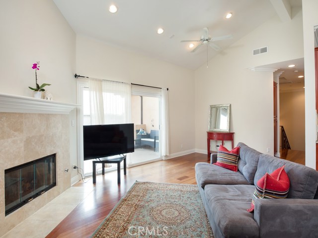 Living room welcomes a stylish fireplace with vaulted ceilings and recessed lighting.