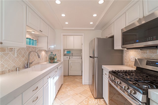 Kitchen with Granite Countertops, Stainless Steel appliances. Leading to Laundry room