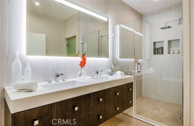 The master bath has a true walk in shower, double sinks with backlit vanity mirrors and a spa-like soaking tub
