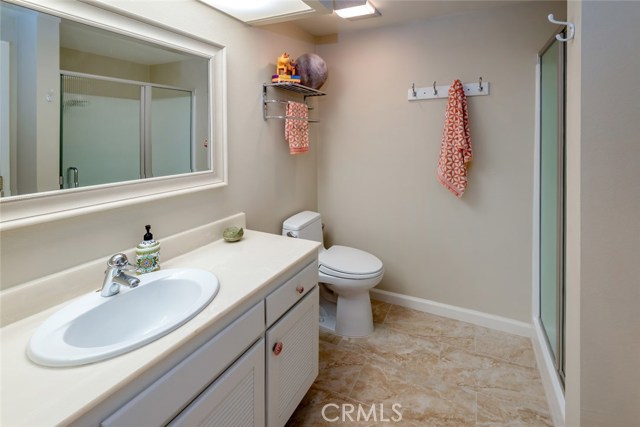 Upgraded 3/4 Bath with Corian counter top, walk in shower, & tile floor with a natural stone look.  There is a large linen closet located in this bathroom.