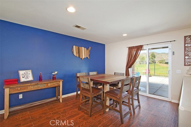 Spacious dining room with wood look tile floors and slider to patio