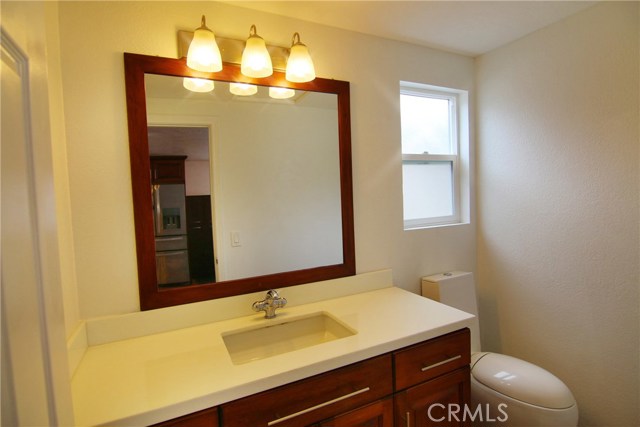 Remodeled powder room with stone counter tops, upgraded cabinets and modern dual flush toilet.