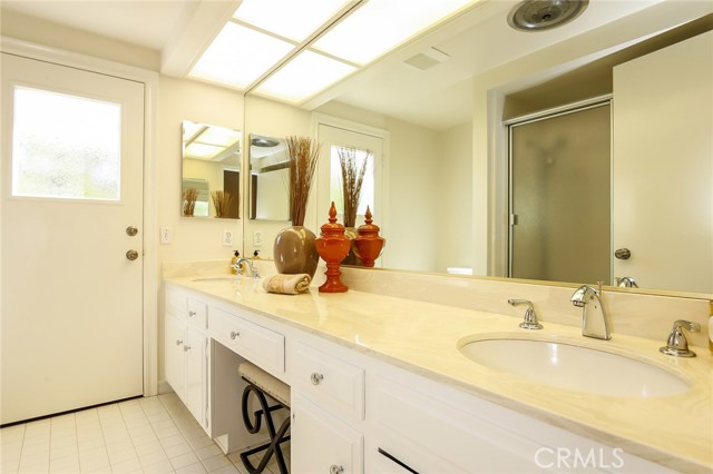 Plenty of space for everyone in this bathroom with dual sinks and access to the backyard