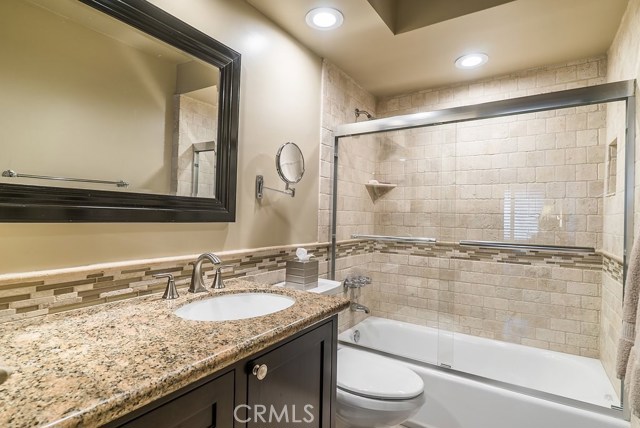 Two remodeled bathrooms, both with new bathtubs surrounded by glass doors and Travertine stone tile.  Equipped with new cabinets, faucets and sinks with granite countertops.