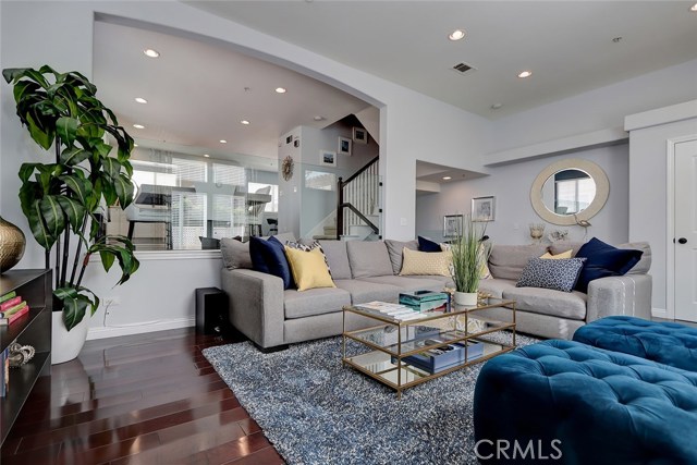 Expansive great room area with open view to dining room, kitchen, and entry area.