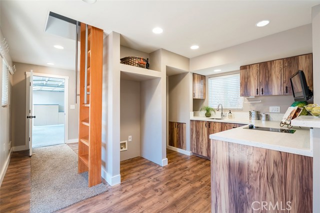 Kitchen in the cottage/back house with ladder leading to the loft and door leading to garage.