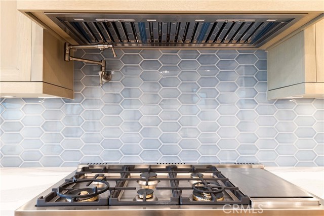 Bertazzoni- Professional Series 48” All-Gas Range with dual convection fan, 6 Brass Burners, Side Griddle and Warmer Oven. Retractable Pot Filler Water Faucet on the wall. Note the outlets are discretely placed under the cabinets allowing a clean look on the custom tile backsplash.