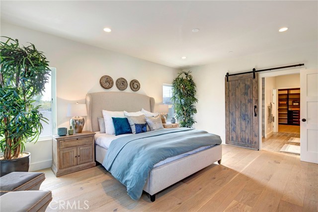 Master bedroom with barn door to master bathroom and walk-in closet in the background.