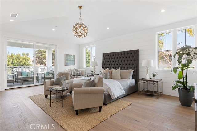 Luxurious master suite with sliding French doors that lead to a covered skylit balcony