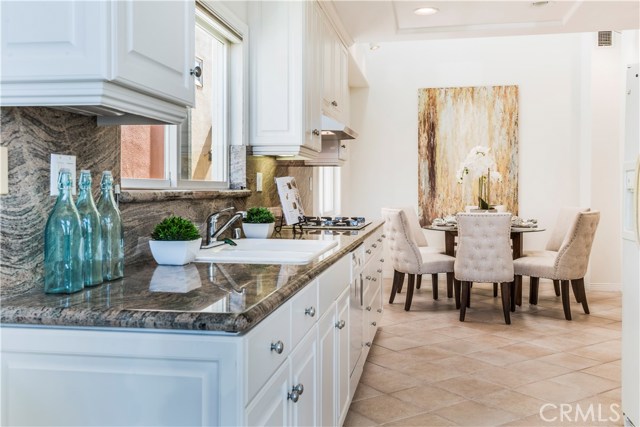 Kitchen with granite counter tops and backsplash and dining room