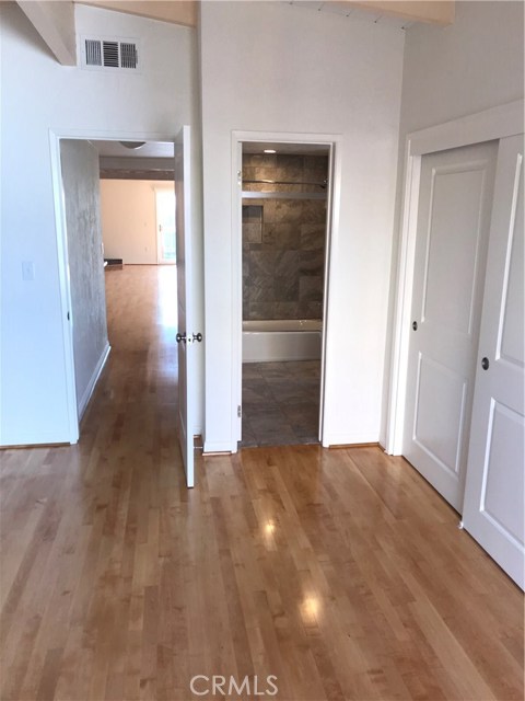 Spacious master bedroom with high wood beam ceilings.