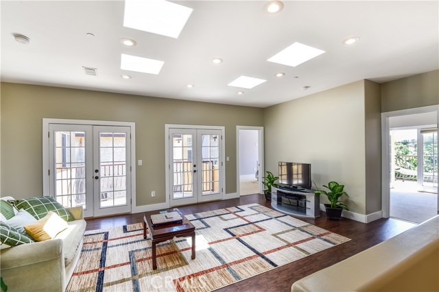 Skylights and french doors flood the upstairs open area with natural light.