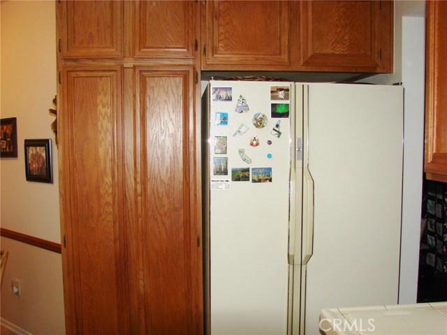 ANOTHER BANK OF CUPBOARDS SURROUNDS THE REFRIGERATOR. EVEN MORE PANTRY SPACE FOR YOU TO STORE FOOD.